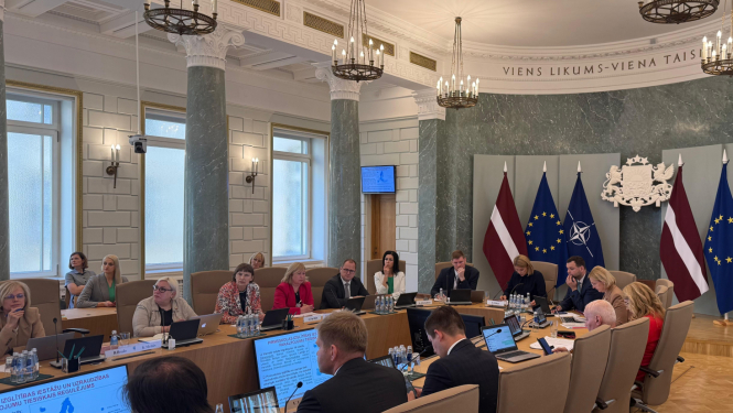 demogrāfisko lietu padomes sēdes attēls, kā ministri sēž pie ministru kabineta galda