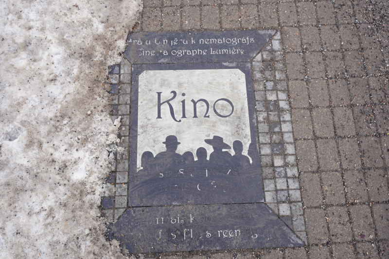 Foto redzams piemiņas zīme uz bruģa - Piemiņas zīme pirmajam kino seansam Rīgā