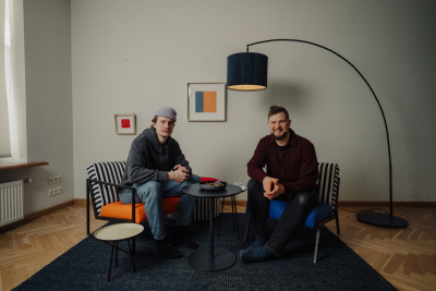 Fotogrāfs Mārcis Gaujenietis bildē ar "Vecāku organizācijas" pārstāvi sēž un runājas 