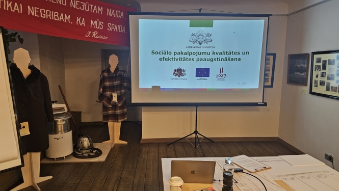 Bilde no domnīcas pasākuma, runātājs un prezentācija
