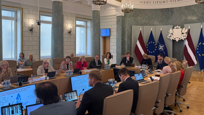 demogrāfisko lietu padomes sēdes attēls, kā ministri sēž pie ministru kabineta galda
