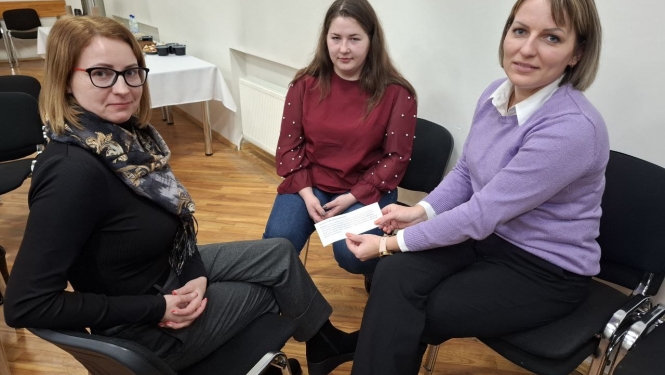 Semināra norise — dalībnieki sēž uz krēsliem zālē