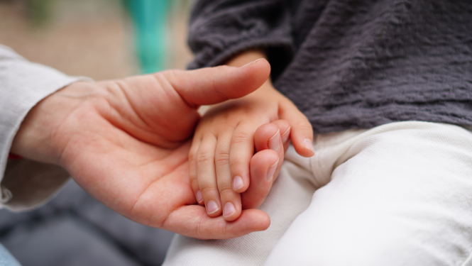 Vecāks tur bērna roku