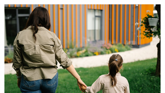 mamma ar meitu sadevušas rokās, iet prom, un apakšā attēloti LM logo