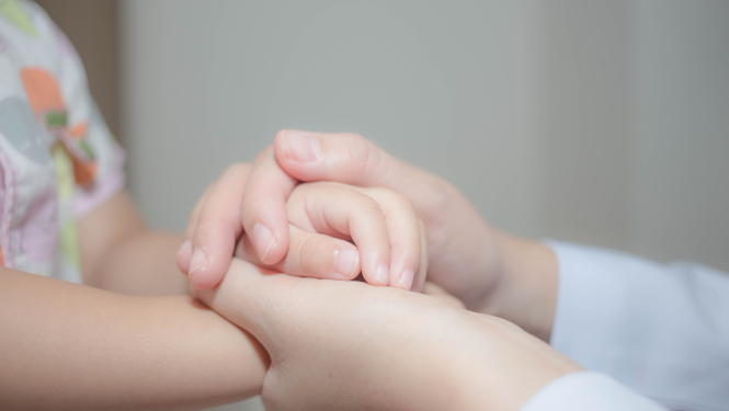 pieaugušais un maza bērns sadevies rokās, pieaugušais sniedz bērnam palīdzību