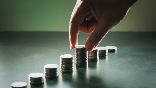 Euro monētas salikas kaudzītēs un bildē roka cilā monētiņas