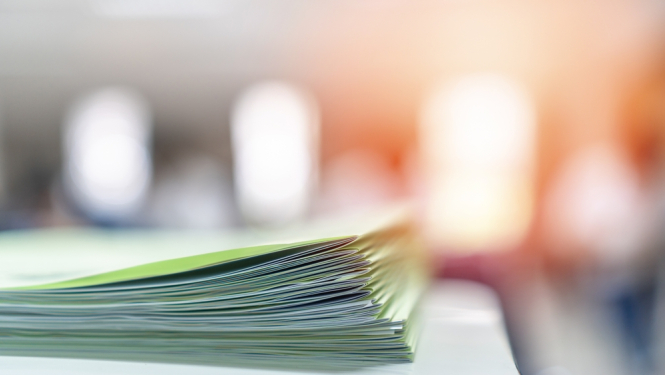 attēlā zaļas mapītes saliktas viena uz otras un fons miglains