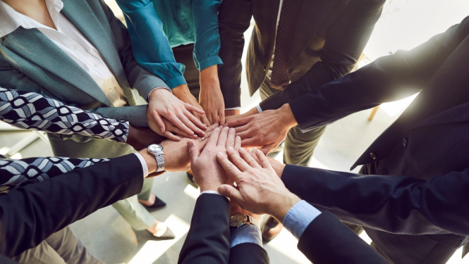 saliktas rokas septiņiem cilvēkiem viena virs otras, lai attēlotu sadarbošanos