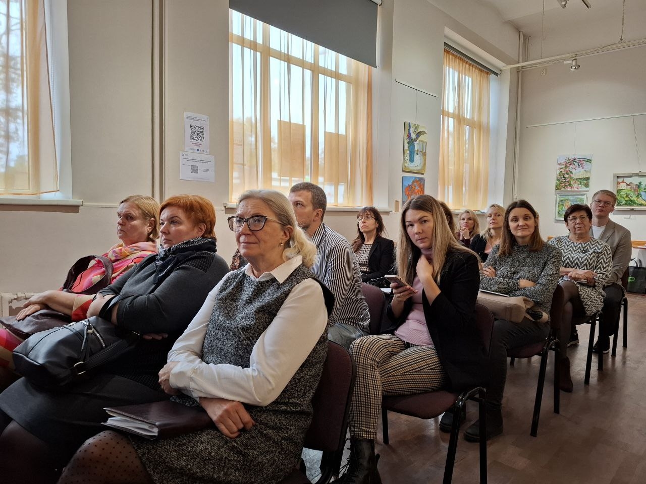 Semināra norise — dalībnieki sēž uz krēsliem zālē