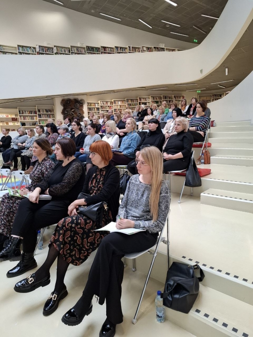 Semināra norise — dalībnieki sēž uz krēsliem zālē