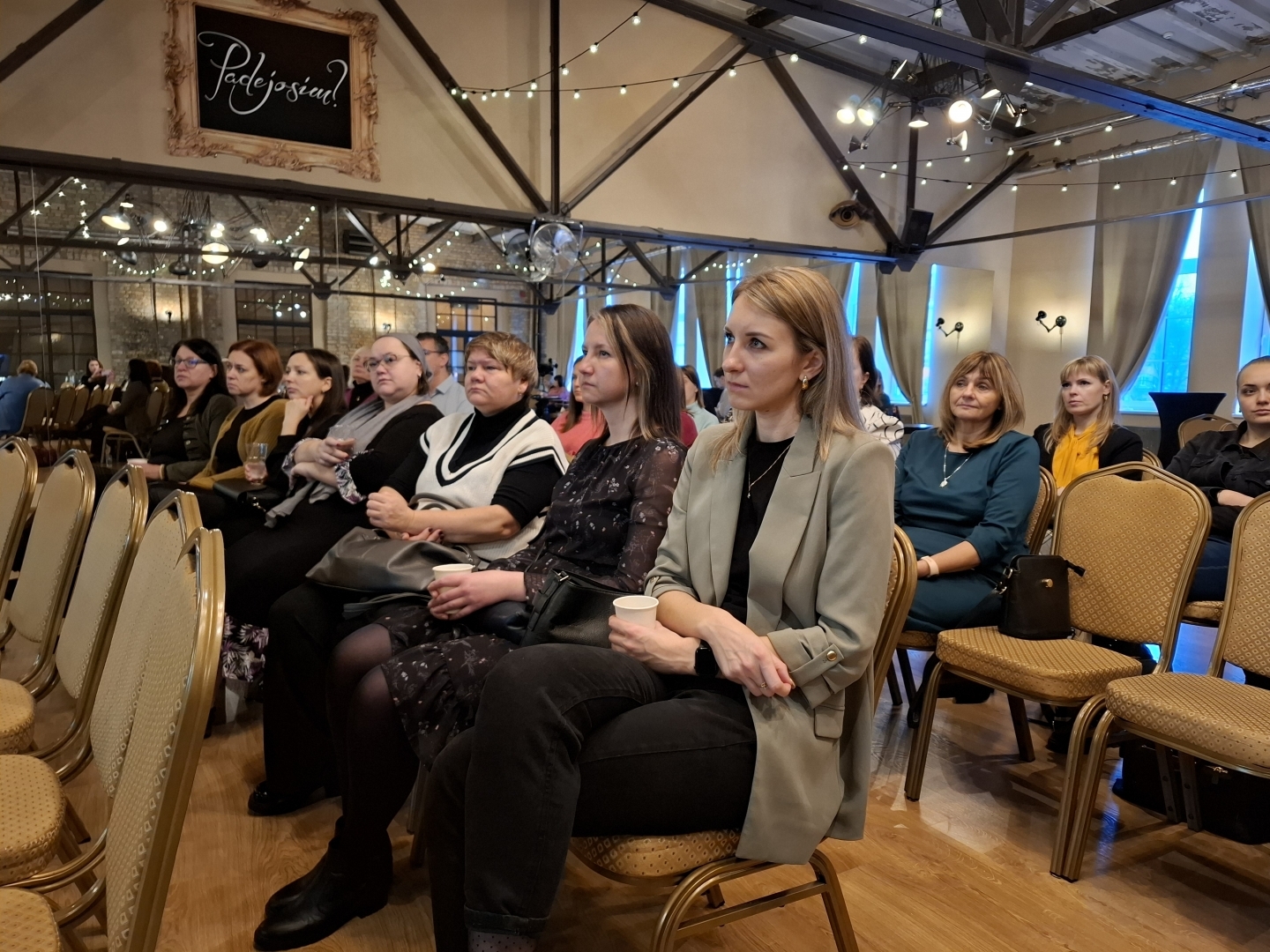 Semināra norise — dalībnieki sēž uz krēsliem zālē